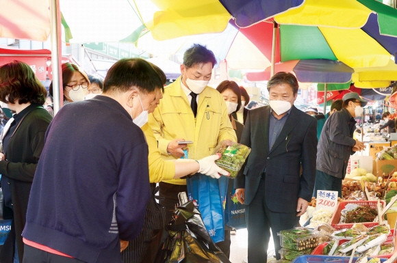 이창우(가운데) 서울 동작구청장이 지난달 29일 사당동 남성사계시장을 찾아 장을 보고 있다. 이 구청장은 동작사랑상품권 발행액을 확대하고 가맹점 경영보전금을 지원하는 등 소상공인 살리기에 힘쓰고 있다. 동작구 제공