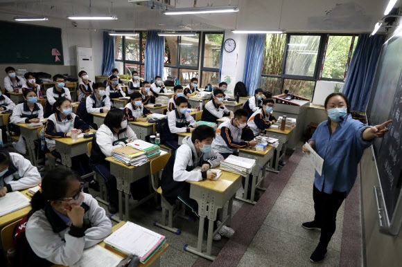 코로나19 감염병이 처음 발생해 전 세계에 막대한 피해를 끼친 후베이성 우한의 중고교가 처음으로 문을 연 6일 마스크를 쓴 교사와 학생들이 수업에 열중하고 있다. 차이나 데일리 제공 로이터 연합뉴스 