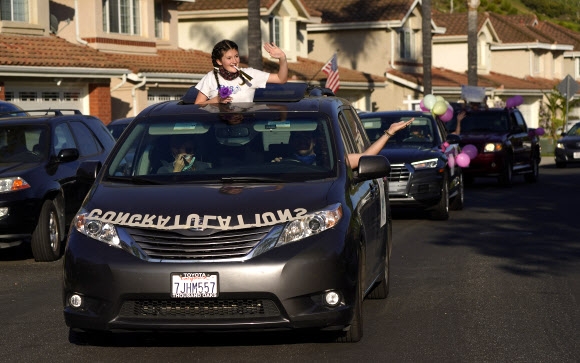 지난 1일(현지시간) 가족과 친구들이 미국 애리조나 그랜드캐년대 졸업생을 차량에 타고 지나가며 축하해주고 있다. AP통신