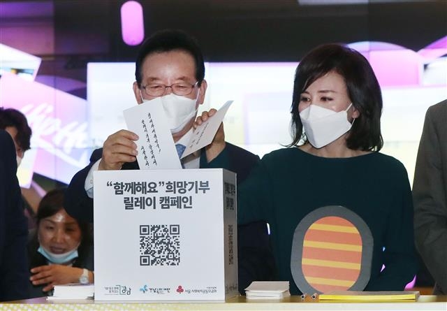 정순균(왼쪽) 강남구청장이 지난 6일 코엑스몰에서 열린 ‘함께해요 희망기부릴레이 캠페인’에 참석, 아내와 함께 성금이 든 봉투를 모금함에 넣고 있다. 강남구 제공