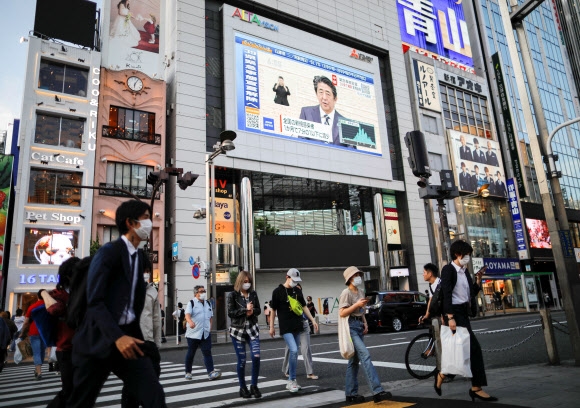 도쿄 시내 대형 스크린에 비치는 아베 기자회견