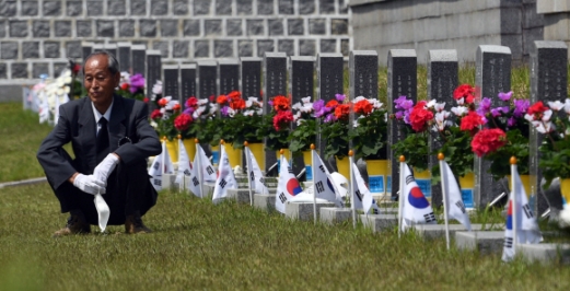 잊을 수 없는 그날의 아픔 5·18 민주화운동 40주년을 하루 앞둔 17일 광주 북구 국립 5·18민주묘지에서 희생자의 묘비를 찾은 유족이 마스크를 벗은 채 쪼그려 앉아 생각에 잠겨 있다. 박지환 기자 popocar@seoul.co.kr