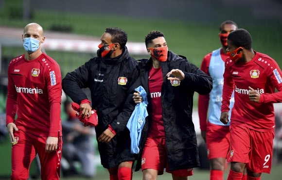 18일 두 달 만에 재개된 독일 프로축구 분데스리가의 레버쿠젠 선수들이 브레멘과의 경기 하프타임 때 마스크를 쓰고 이야기를 나누는 모습. AP 연합뉴스