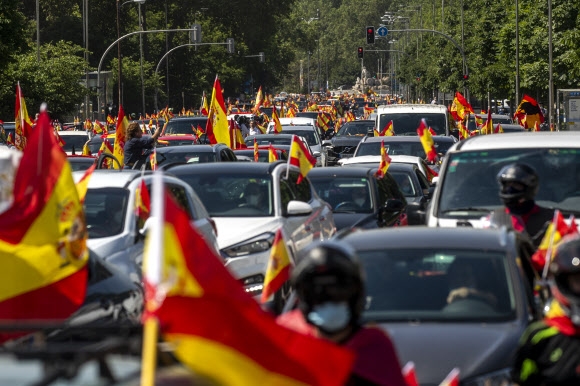 스페인의 극우 정당 복스(Vox) 당이 23일(현지시간) 수도 마드리드에서 주최한 봉쇄 해제 요구 집회에 국기를 꽂은 수천대의 차량이 참여하고 있다. 마드리드 AP 연합뉴스 