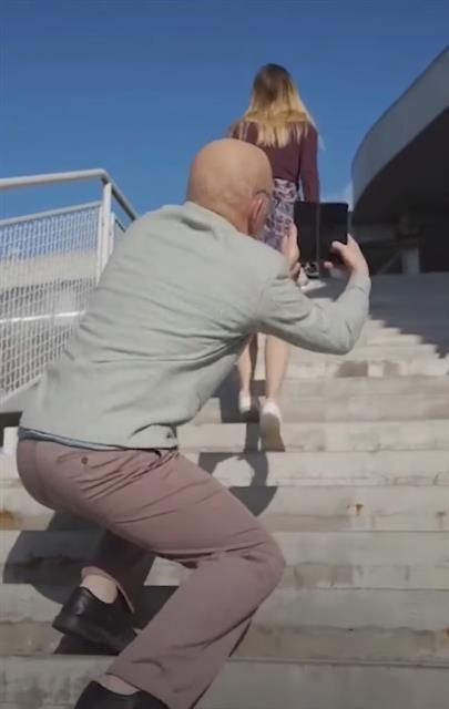 한 노인이 계단을 오르는 젊은 여성의 뒷모습을 몰래 촬영하고 있는 광고의 한 장면. LG전자 폴란드 법인 틱톡 계정 영상 캡처