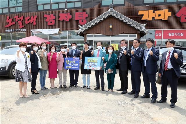 지난 18일 정장선(오른쪽 여섯 번째) 평택시장과 시의원·간부공무원들이 코로나19 확진환자가 다녀가 피해를 입은 업소에서 파이팅을 하고 있다. 평택시 제공