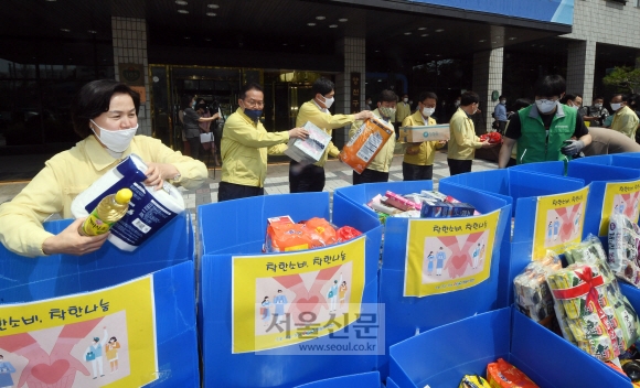 26일 서울 양천구청에서 열린 ‘마음 더하기 마음’ 착한 소비 독려 행사에서 김수영(왼쪽) 양천구청장 등 구 관계자들이 정부 긴급재난지원금으로 구매한 기부 물품을 차량에 옮겨 싣고 있다. 이 행사는 정부 긴급재난지원금으로 지역 상권을 살리는 ‘착한 소비’와 어려운 이웃에 대한 ‘착한 나눔’을 동시에 실천하자는 캠페인이다. 기부 물품은 양천구 푸드뱅크마켓센터에 전달했다. 정연호 기자 tpgod@seoul.co.kr