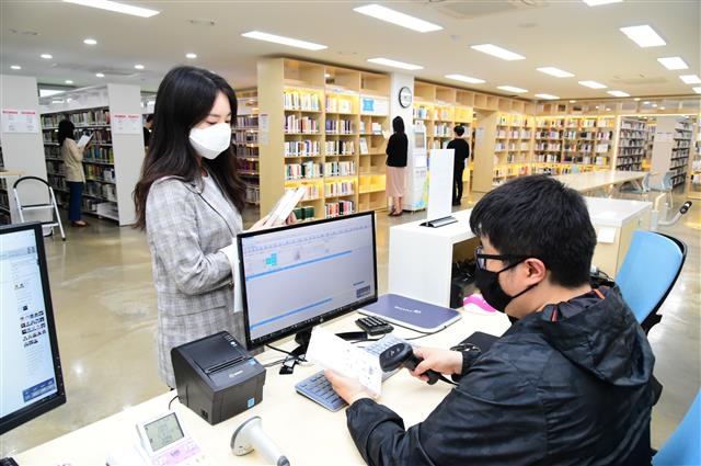 지난 26일 재개관한 중랑구립정보도서관을 찾은 주민이 책을 빌리고 있다. 중랑구 제공