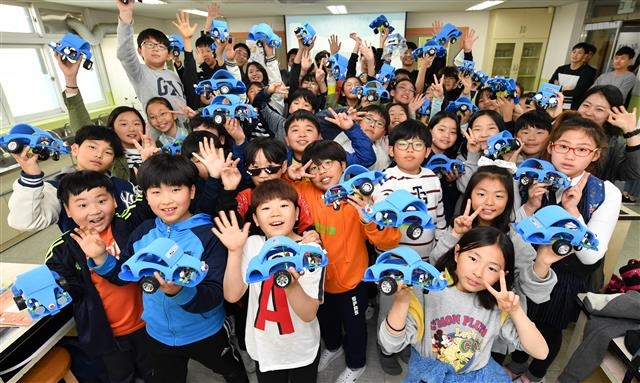 현대모비스 ‘주니어 공학교실’에 참가한 서울 송파구 방이초등학교 학생들이 자동차 모형을 들어 보이고 있다.  현대모비스 제공