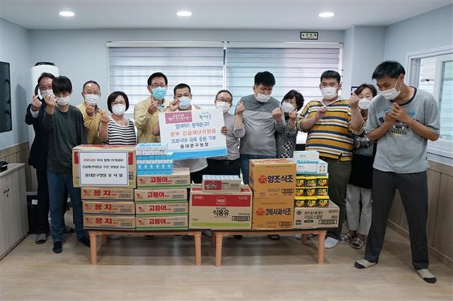 유덕열(왼쪽 다섯 번째) 서울 동대문구청장이 28일 장애인 단기거주시설인 ‘하늘꿈터’를 찾아 자신의 재난지원금으로 구매한 생필품을 기부한 뒤 기념촬영을 하고 있다. 동대문구 제공