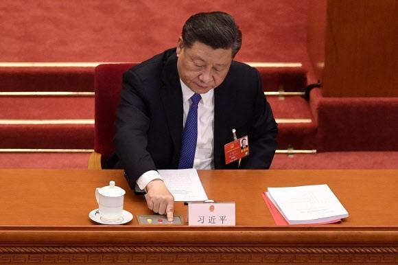 시진핑 중국 국가주석이 지난 28일(현지시간)  전국인민대표대회에서 홍콩 보안법에 투표하고 있는 모습.  베이징 AFP 연합뉴스