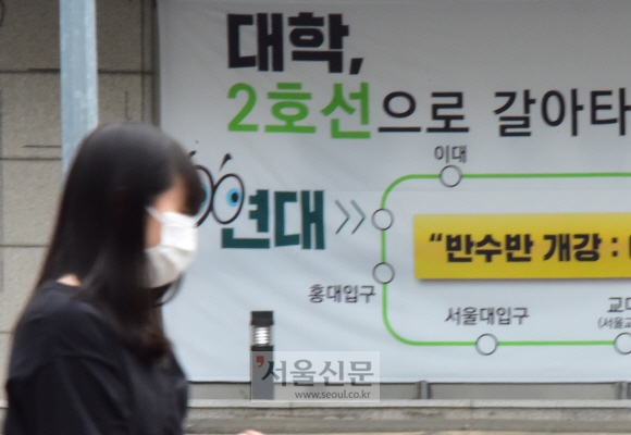 서울 양천구 목동 소재 고등학교 학생 가족이 코로나19 확진 판정을 받으면서 학원가에도 비상이 걸렸다. 31일 마스크를 쓴 한 시민이 학원가 앞을 걷는 모습. 이종원 선임기자 jongwon@seoul.co.kr