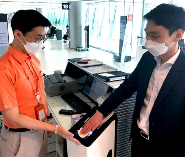 제주항공 탑승객이 탑승권을 직원과의 접촉 없이 스스로 기계에 인식시키고 있다.  제주항공 제공
