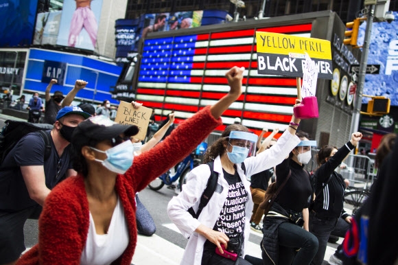 흑인 남성 조지 플로이드가 백인 경찰의 과잉 진압으로 숨진 이후 인종차별 규탄 시위가 미국 전역으로 확산되고 있는 가운데 2일(현지시간) 뉴욕 타임스 스퀘어에서 시위대가 거리행진을 하고 있다. AP 연합뉴스