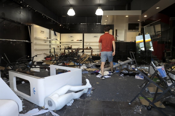 2일(현지시간) 미국 세인트루이스의 약탈 피해를 입은 가게를 한 남성이 살펴보고 있다. AP 연합뉴스