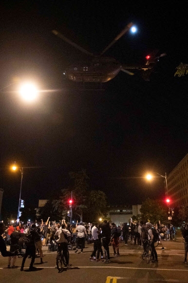 지난 1일(현지시간) 저녁 인종차별 반대 시위대가 워싱턴DC 백악관 근처까지 접근하자 미 육군 헬기가 저공비행하며 시위대를 해산하고 있다. 워싱턴DC AFP 연합뉴스