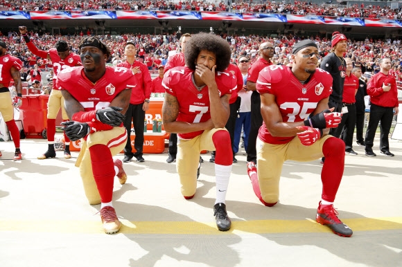 지난 2016년 10월 2일 미국프로풋볼(NFL) 샌프란시스코 포티나이너스(49ers) 팀의 일부 선수들이 국가가 연주되는 동안 무릎을 꿇는 행동으로 인종차별에 항의했던 모습. 2020.6.6  EPA 연합뉴스