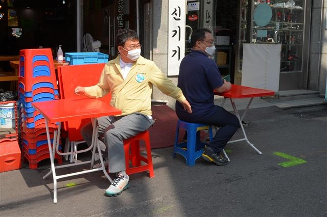 서양호(왼쪽) 서울 중구청장이 지난 5일 을지로 노가리호프 골목에서 직접 야외 테이블 간격을 맞춰 보고 있다. 중구 제공