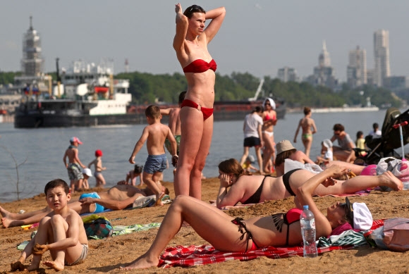 러시아 모스크바 시민들이 코로나19 자가격리 해제를 하루 앞둔 8일(현지시간) 운하 주변 공원에서 수영복을 입고 일광욕을 즐기고 있다. 타스 연합뉴스