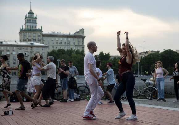 코로나19 자가격리 조치 해제 첫 날인 9일(현지시간) 러시아 모스크바 강 둔치에 모인 시민들이 춤을 추고 있다. AP 연합뉴스
