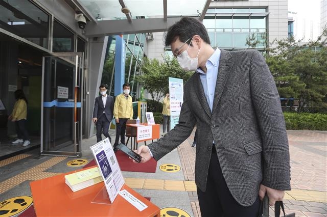 정원오 서울 성동구청장이 지난 1일 구청 앞에 있는 근거리무선통신(NFC) 기능과 QR코드를 이용한 모바일 전자출입명부 표지판에서 본인 인증을 하고 있다. 성동구 제공
