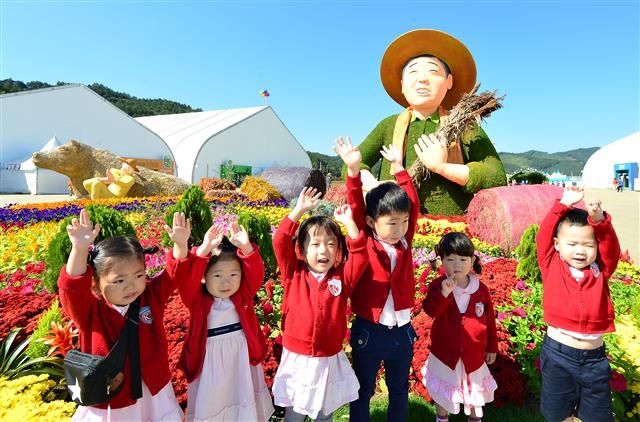 괴산 세계유기농엑스포 행사장의 농부 조형물 앞에서 즐거운 시간을 보내는 유치원생들.  충북도 제공