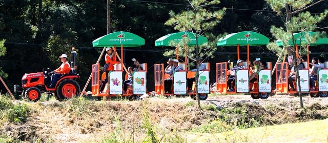 방문객들이 트랙터를 활용해 만든 기차를 타고 유기농엑스포 행사장을 둘러보고 있다. 충북도 제공