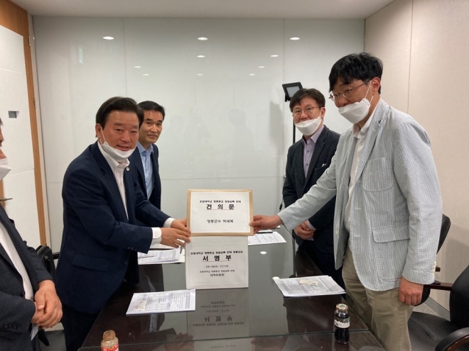 김창호 영동부군수(왼쪽)가 유원대 정원 감축을 반대하는 군민 서명부를 1일 한국대학교육협의회에 전달하고 있다. 영동군 제공  