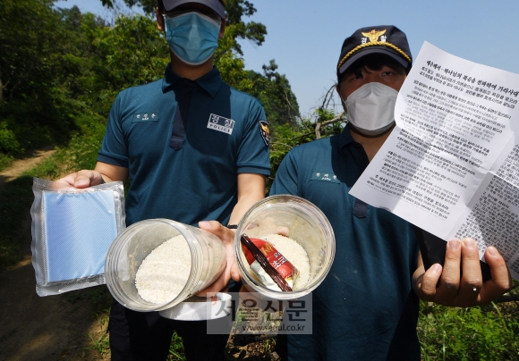 16일 인천 강화군 석모도 해안 인근에서 경찰들이 쌀과 성경, 초코파이가 든 페트병을 발견한 후 들어보이고 있다. 2020.6.16  오장환 기자 5zzang@seoul.co.kr