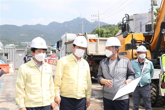 지난 10일 박준희(왼쪽 두 번째) 서울 관악구청장이 도림천 복개 철거 및 친수공간 조성 공사현장을 찾아 공사 관계자들에게 여름철 수방대책과 공사진행 상황을 듣고 있다. 관악구 제공