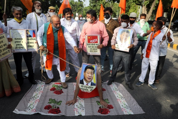 인도의 힌두우익단체연합인 힌두교전선(UHF) 시위대가 지난 18일 인도 뉴델리에서 시진핑 중국 국가주석의 사진을 줄로 묶어 끌며 반중 시위를 벌이고 있다. 뉴델리 EPA 연합뉴스
