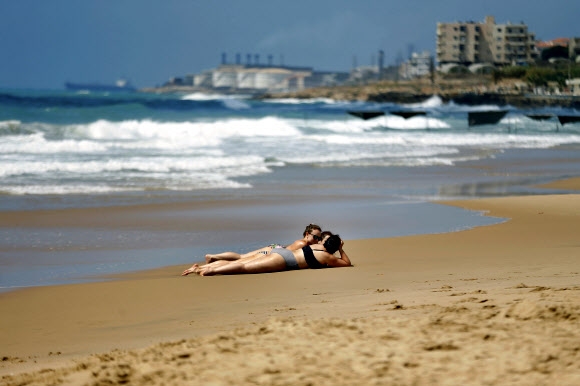 20일(현지시간) 레바논 베이루트 남쪽 라구아바 리조트 해변에서 관광객들이 일광욕을 즐기고 있다. AP 연합뉴스