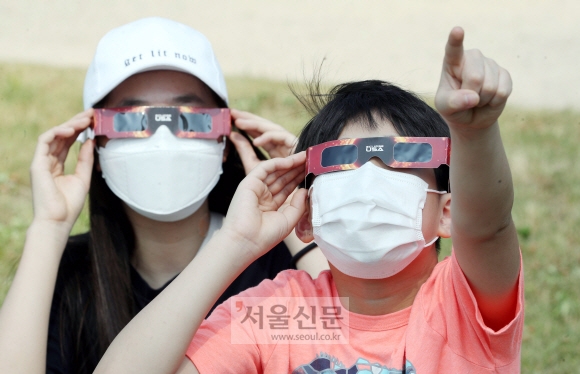 부분일식 현상을 보인 21일 서울 여의도 한강공원을 찾은 시민들이 태양을 관측하고있다. 2020. 6. 21  오장환 기자 5zzang@seoul.co.kr