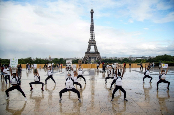 ‘세계 요가의 날’을 맞아 에르민 푸르니에 요가 단체 회원들이 21일(현지시간) 프랑스 파리 에펠탑 앞 트로카데로 광장에서 인종차별에 항의하며 요가 동작을 펼치고 있다. AFP 연합뉴스