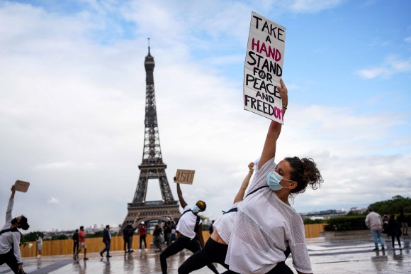 ‘세계 요가의 날’을 맞아 에르민 푸르니에 요가 단체 회원들이 21일(현지시간) 프랑스 파리 에펠탑 앞 트로카데로 광장에서 인종차별에 항의하며 요가 동작을 펼치고 있다. AFP 연합뉴스