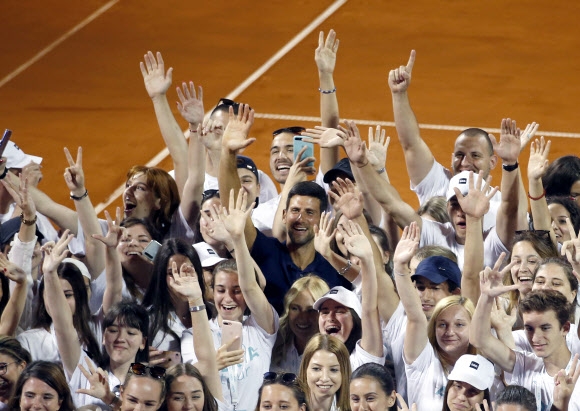 남자 테니스 세계 랭킹 1위 노바크 조코비치(가운데)가 지난 14일 세르비아 베오그라드에서 자신이 주최한 자선 테니스 대회 아드리아 투어에서 참가자들과 붙어 기념 촬영을 하고 있다. 세르비아 AP 연합뉴스