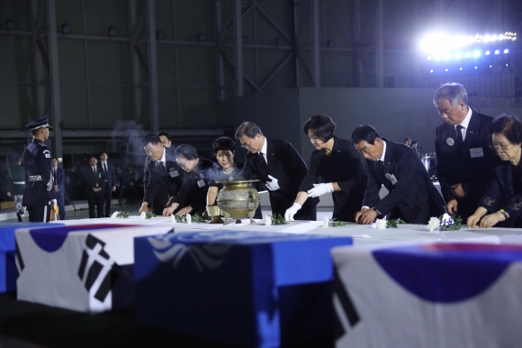 문재인 대통령이 25일 서울공항에서 열린 6·25전쟁 70주년 행사에서 국군 전사자들의 유해에 헌화를 하고 있다. 도준석 기자 pado@seoul.co.kr