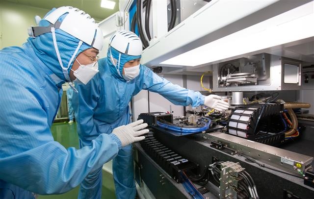 삼성전자 직원(왼쪽)과 반도체 장비 제조업체인 ‘이오테크닉스’ 직원이 양사가 함께 개발한 반도체 레이저 설비를 살펴보고 있다. 삼성전자 제공