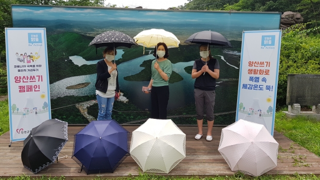 거리두기와 폭염피해 예방을 위해 양산을 쓰자는 캠페인을 벌이고 있는 진천군 자원봉사센터 회원들. 진천군 제공.