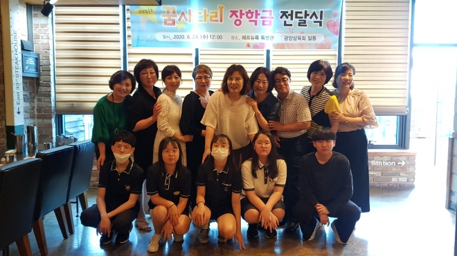 광양삼육회 회원들이 중학생들에게 장학금을 전달한 후 기념사진을 찍고 있다.