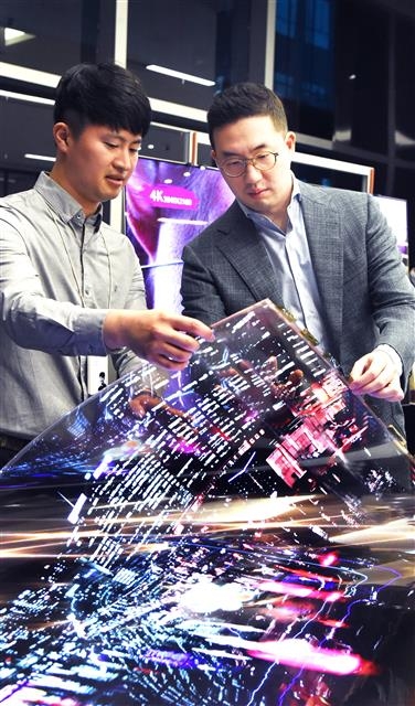 구광모(오른쪽) LG 회장이 지난 2018년 9월 서울 강서구 마곡 LG사이언스파크에서 연구원과 함께‘투명 플렉시블 OLED’를 살펴보고있다.  LG 제공