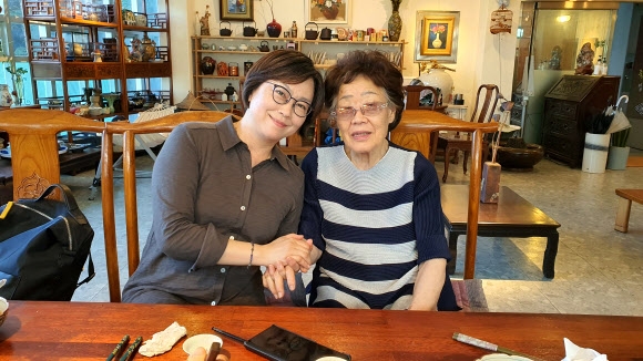 지난 26일 대구 남구 한 카페에서 일본군 ‘위안부’ 피해자 이용수(오른쪽) 할머니와 이나영 정의기억연대 이사장이 손을 맞잡고 있다. 대구 연합뉴스