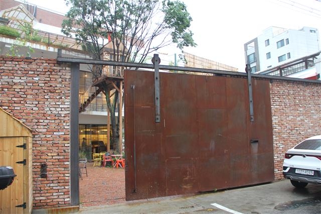 사진촬영 명소로 떠오른 한 카페의 거대한 철대문이 그 옛날 창고건물임을 짐작게 한다.