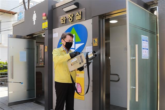 김 구청장이 지난 4월 3일 자양1동 자마장공원 화장실에서 직접 방역활동을 하고 있다. 광진구 제공