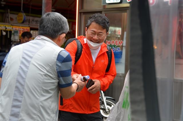 서양호(오른쪽) 서울 중구청장이 1일 출근길에 중구 중앙시장을 들러 한 상인에게 음료수를 건네받으며 활짝 웃고 있다. 중구 제공