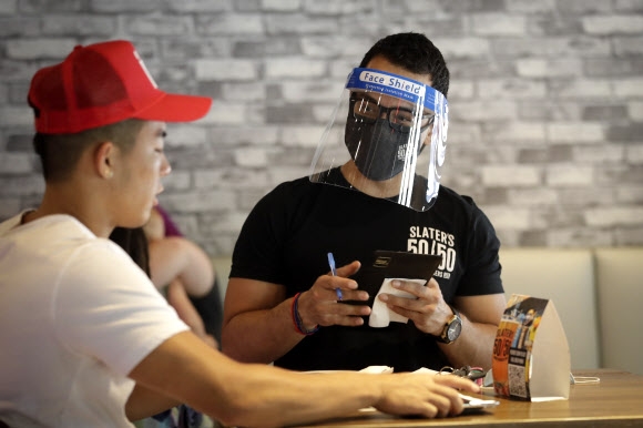 미국 캘리포니아의 한 식당에서 1일 얼굴 보호 마스크를 착용한 점원이 음식 주문을 받고 있다. 연합뉴스