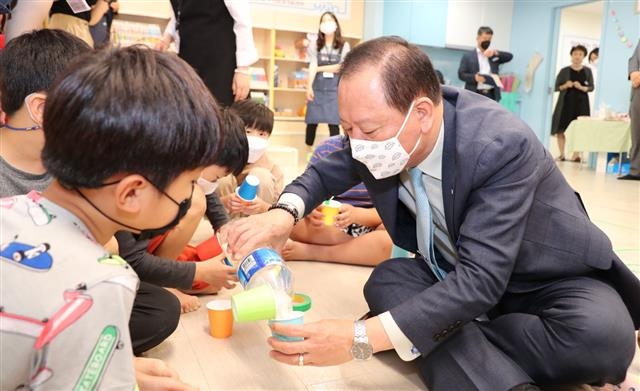 유동균(오른쪽) 서울 마포구청장이 지난달 25일 망원1동 우리동네키움센터를 방문해 아이들과 함께 흔들어서 소리를 내는 악기인 ‘마라카스’를 만들고 있다. 마포구 제공