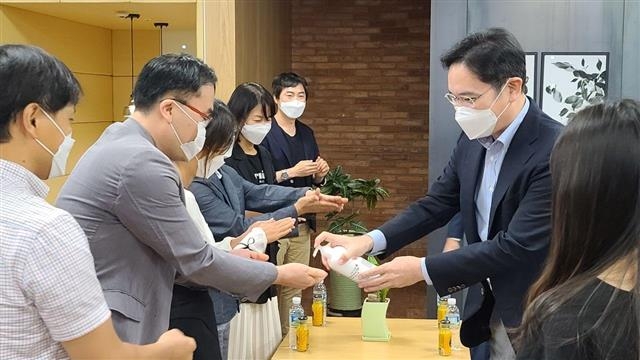 6일 오전 삼성전자 수원사업장을 찾은 이재용(오른쪽) 부회장이 ‘C랩’을 통해 스타트업에 도전하는 직원들과 간담회를 갖기에 앞서 직원들에게 손소독제를 뿌려 주고 있다. 삼성전자 제공