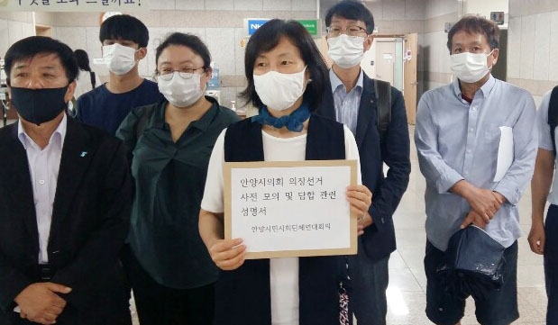 노훈심(가운데 흰마스크) 안양군포의왕 환경운동연합 사무국장 등 연대회의 관계자들이 ‘안양시의회 의장선거 사전 모의 및 담합 관련 성명서’를 시의회에 전달하고 있다. 