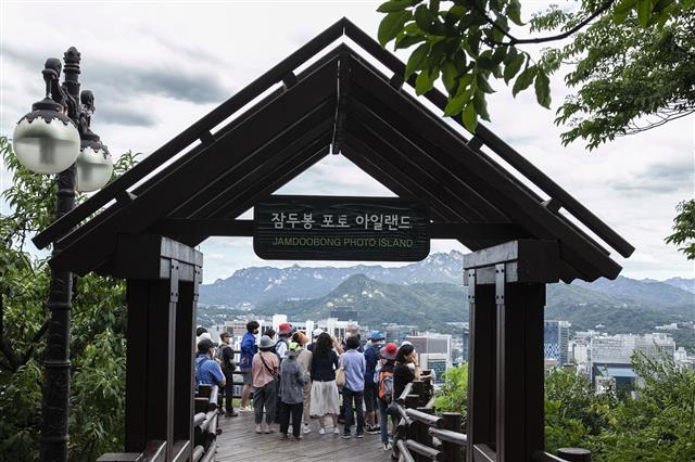 잠두봉 포토아일랜드 전망대에서 참가자들이 눈앞에 펼쳐지는 북한산과 서울 시내 전망을 즐기고 있다.